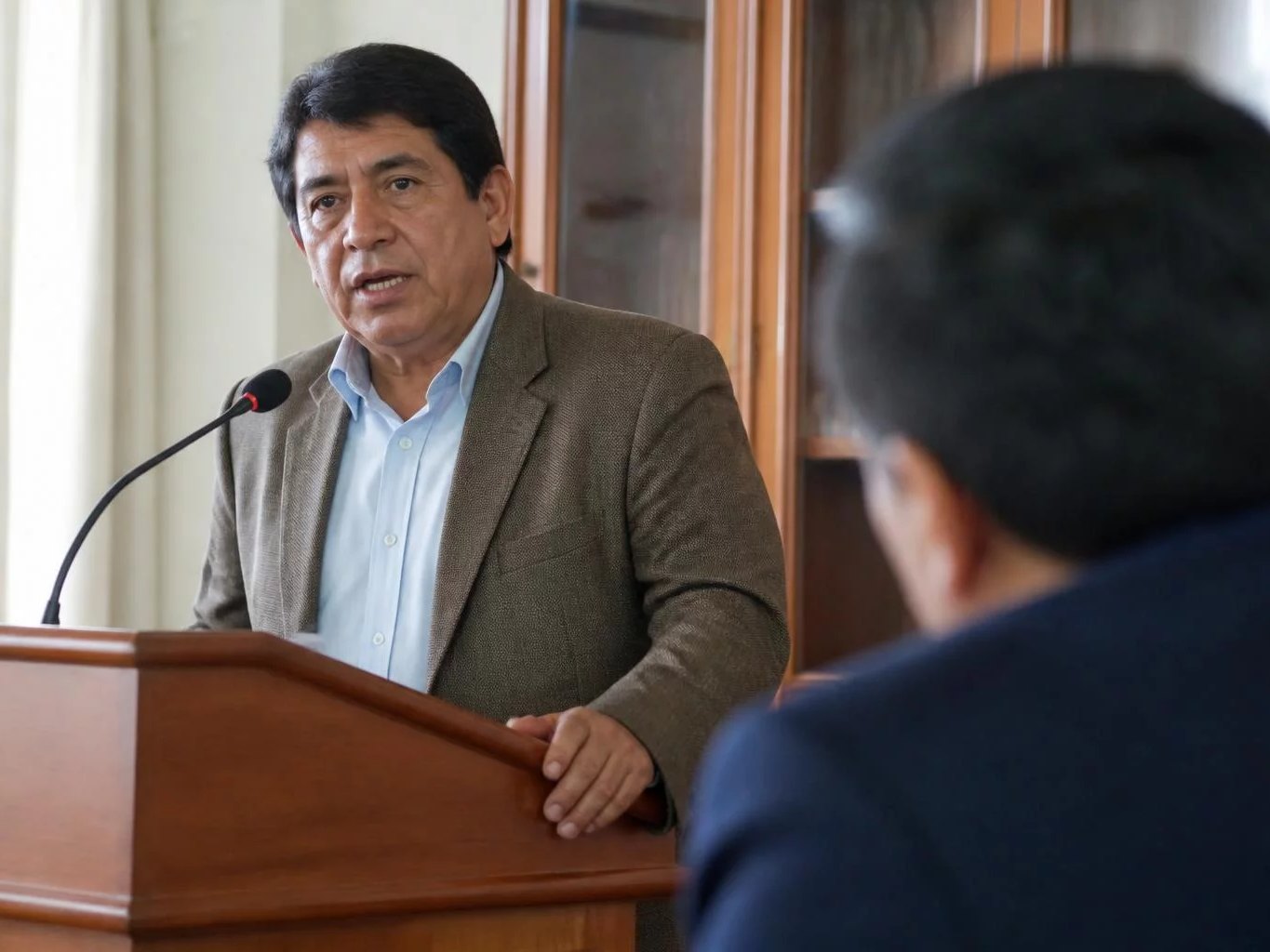 Micrófono en el atril, con el salón desenfocado al fondo