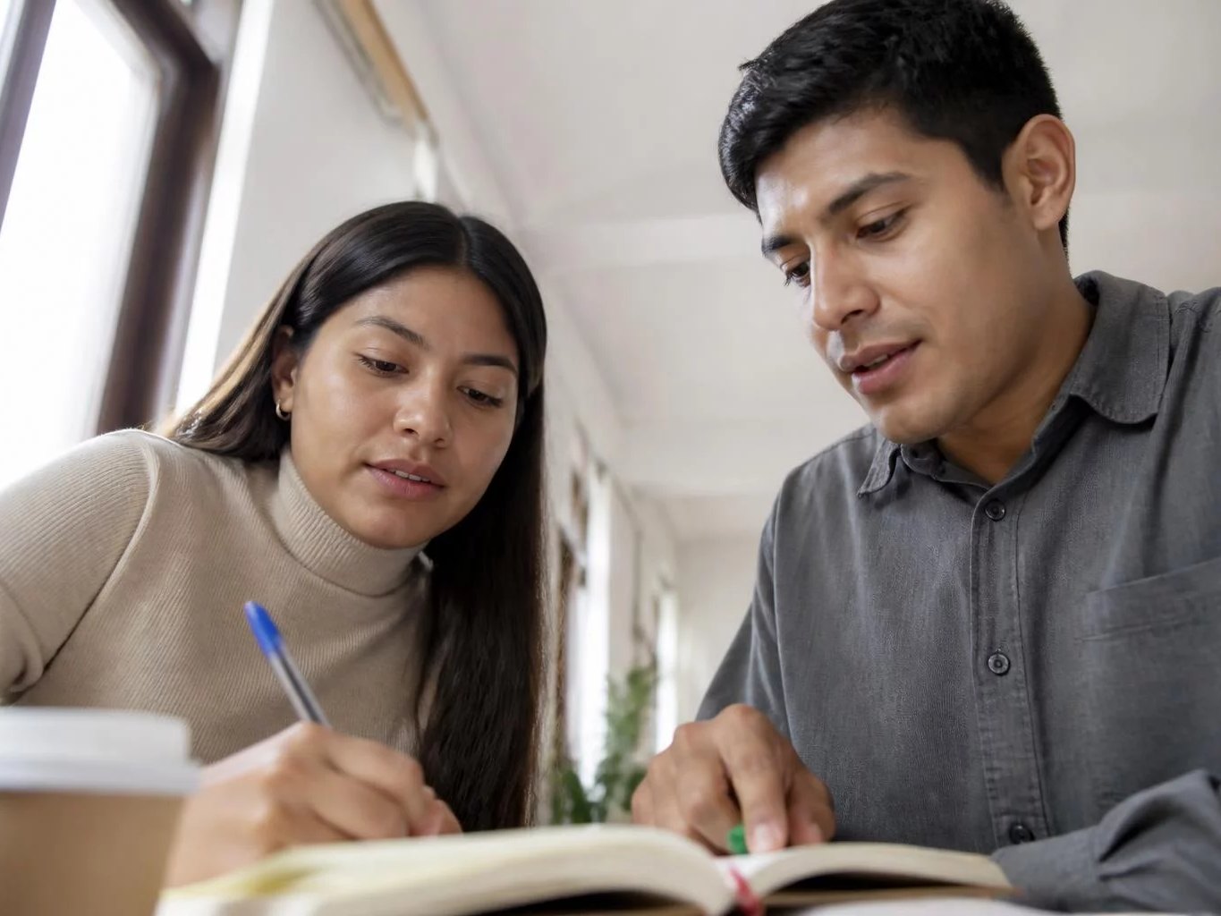 Dos participantes trabajando juntos con cuaderno y plumones